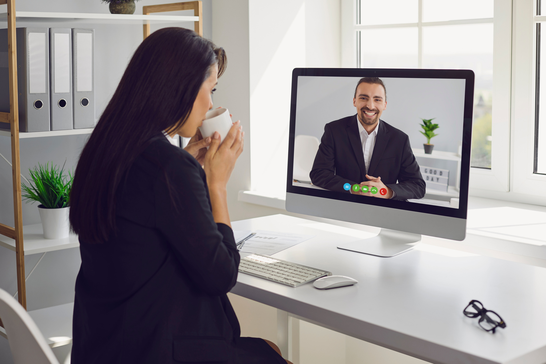 Businesswoman Having Video Chat Meeting in Office while Drinking Coffee